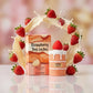 Creative e-commerce shot of the Arabiyat Sugar Strawberry Tres Leches perfume bottle and box inspired by the theme in image_519704.jpg. The items are placed on a glossy white surface, surrounded by an artistic, frozen-in-time splash of condensed milk, heavy cream, and several ripe, glossy red strawberries tumbling around. A soft sprinkle of vanilla powder drifts gently through the air. The background is a soft pastel pink and cream blurred bokeh gradient. Deeply indulgent and sweet fragrance concept. Aspect